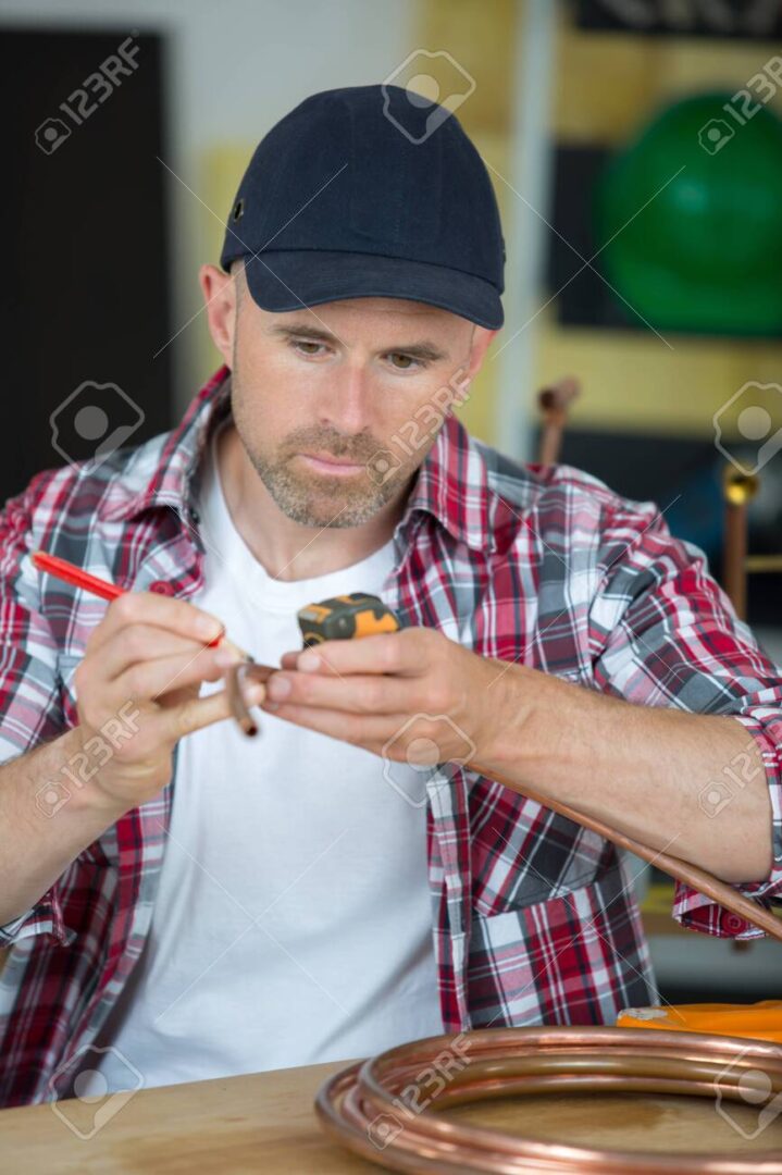 man cutting copper pipe